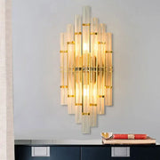 Contemporary gold finish wall sconce with vertical crystal tubes and metallic accents for bedroom lighting
