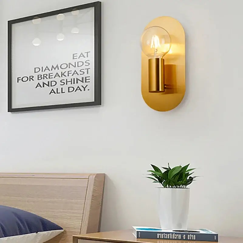 Contemporary gold led wall lamp with gold-toned oval sconce, clear filament bulb, and brass-finished cylindrical base for living room decorbites contemporary gold
