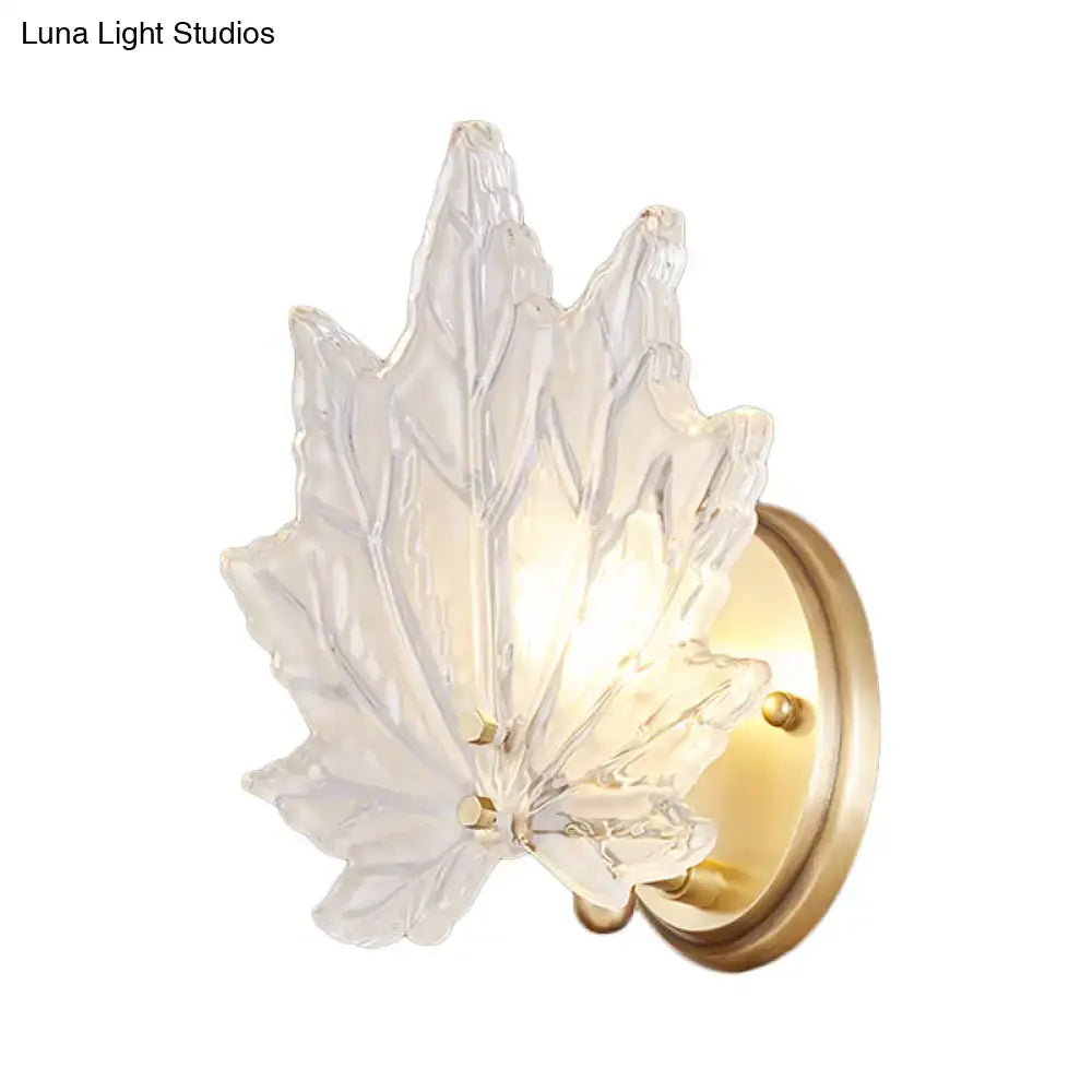 Contemporary clear glass maple leaf bedroom wall light with brass backplate and crystal sconce design