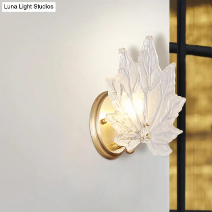 Contemporary wall light featuring a clear glass maple leaf design with a gold-toned metal base for maple leaf bedroom use