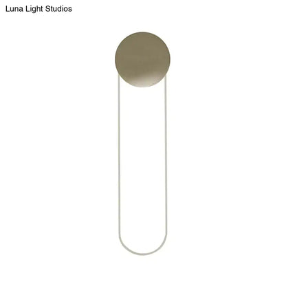 Contemporary gold oblong bedroom wall light fixture with a minimalist brushed brass circular head and curved metal frame 110v 120v