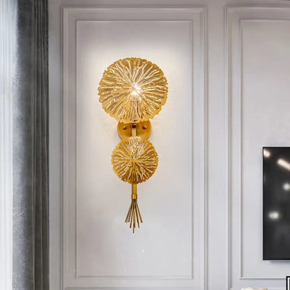 Contemporary gold-toned wall light with two textured sunburst glass discs and a tassel compatible with e12 e14 bulb