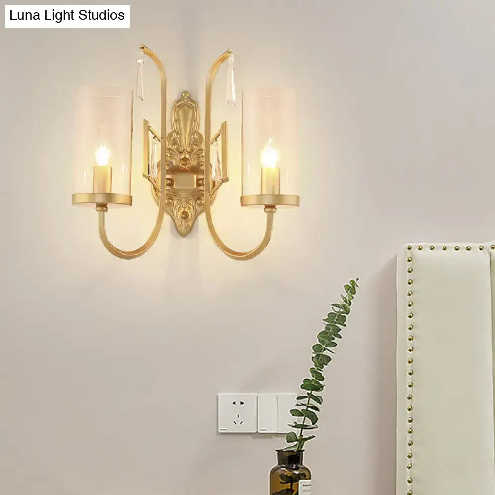 Contemporary gold wall light bedroom sconce with clear glass shade and crystal accents featuring two candle-style bulbs