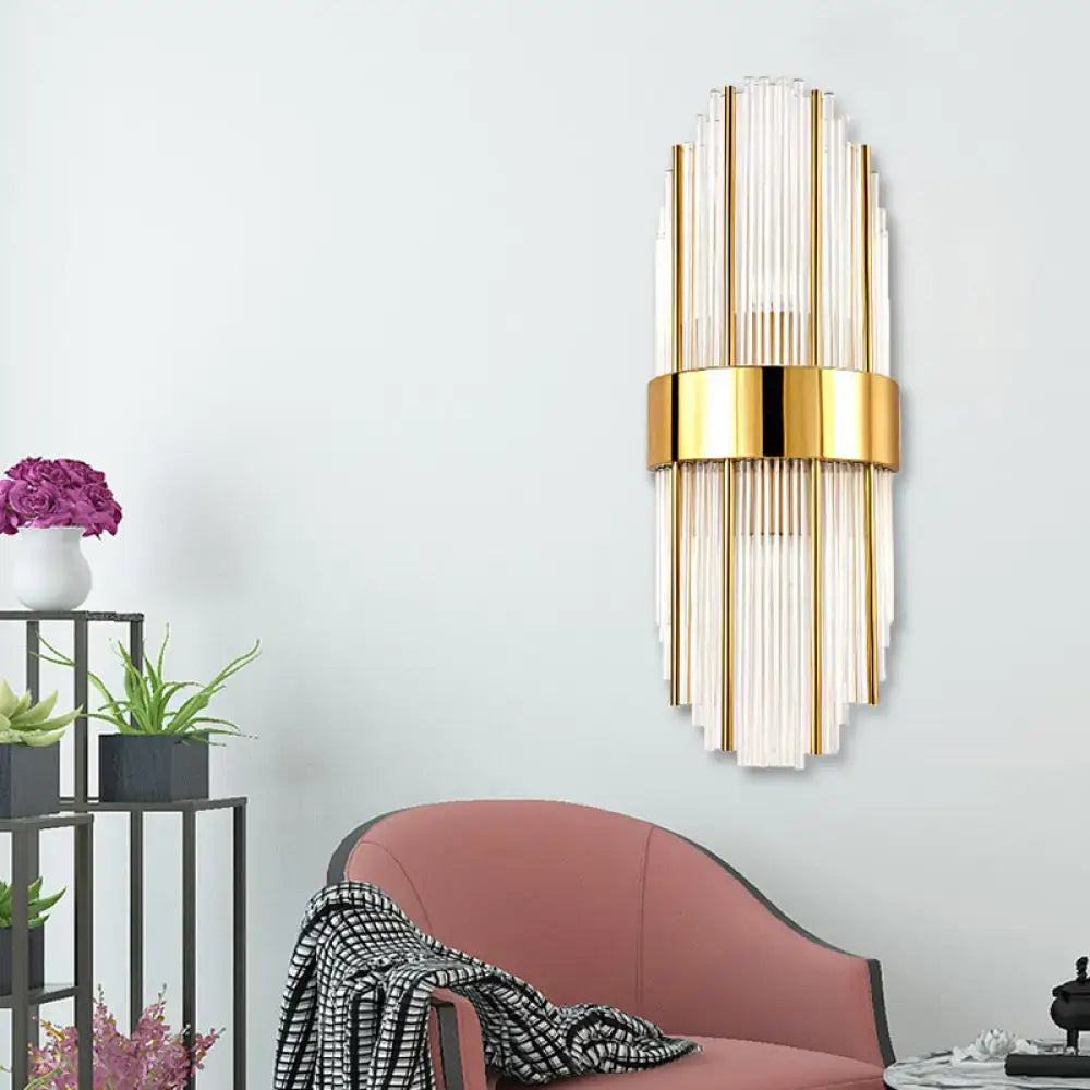 Contemporary gold wall light with clear crystal shade featuring vertical glass tubes and a central metallic band