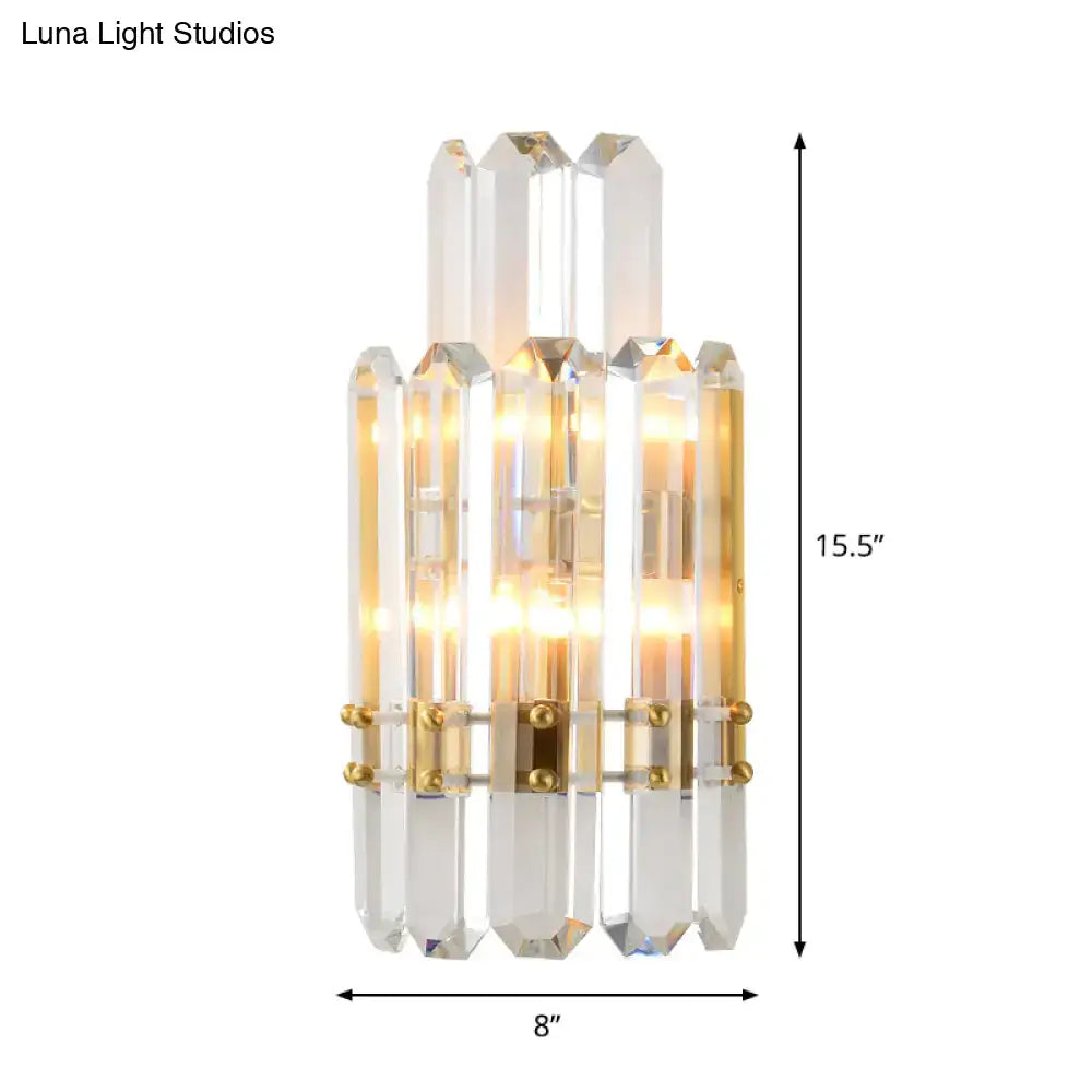 Contemporary gold wall sconce with clear crystal prisms and integrated lighting for dining room use
