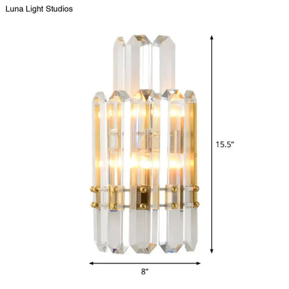 Contemporary gold wall sconce with clear crystal prisms and integrated lighting for dining room use