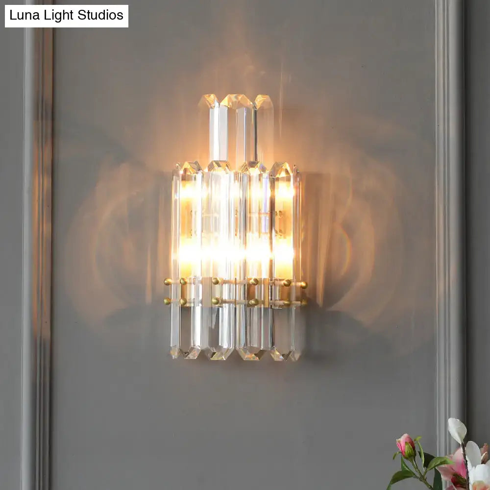 Contemporary gold wall sconce with clear crystal prisms and faceted glass rods for elegant dining room lighting