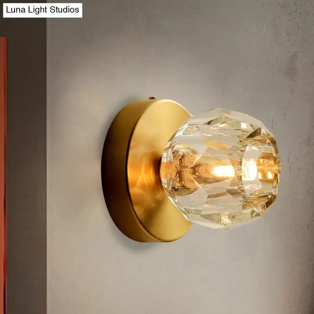 Contemporary golden wall mount lamp featuring a faceted crystal glass shade for elegant living room lighting