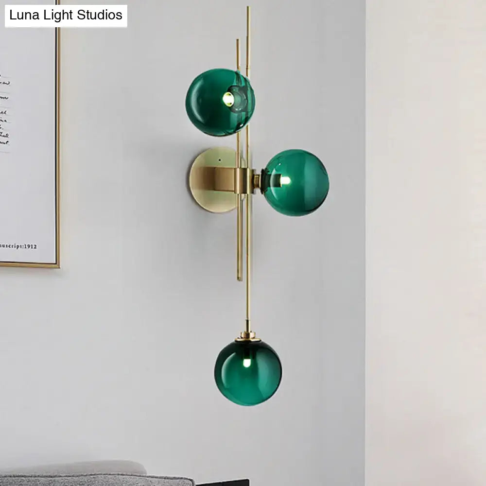 Contemporary green and clear glass globe living room wall sconce with three emerald green glass spheres on brass frame direct wired electric