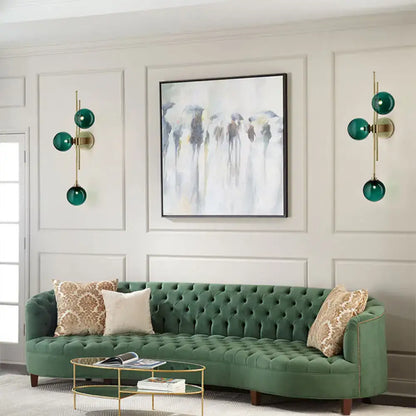 Contemporary green and clear glass globe living room wall sconce lamp with direct wired electric and emerald green velvet sofa