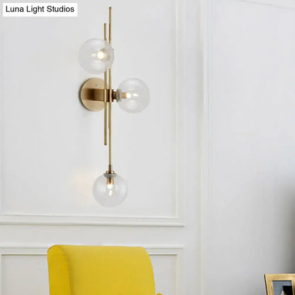 Contemporary green and clear glass globe living room wall sconce with modern brass finish and direct wired electric design
