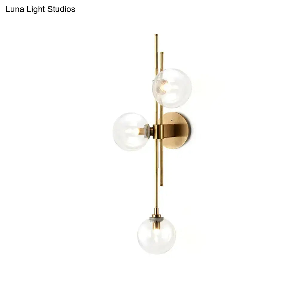 Contemporary brass-finished wall sconce with three green clear glass globe shades direct wired electric for living room