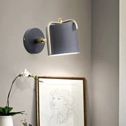 Contemporary green grey wall sconce with sleek cylindrical shade and brass accents for bedroom lighting