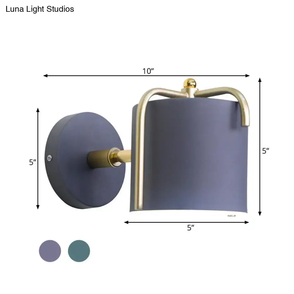 Contemporary green grey sconce featuring a matte gray cylindrical shade with brass-finished metal frame for bedroom
