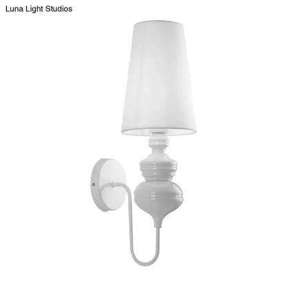 White ceramic wall mount light with tapered fabric shade and curved arm for contemporary bedroom lighting