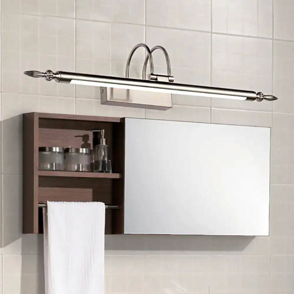 Modern brushed nickel bathroom vanity light with curved arms and decorative finials emitting warm white light