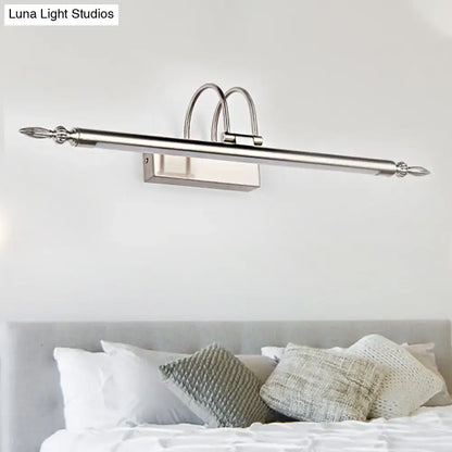 Contemporary nickel finish led wall sconce with silver-toned curved arches and ornate finials providing warm light