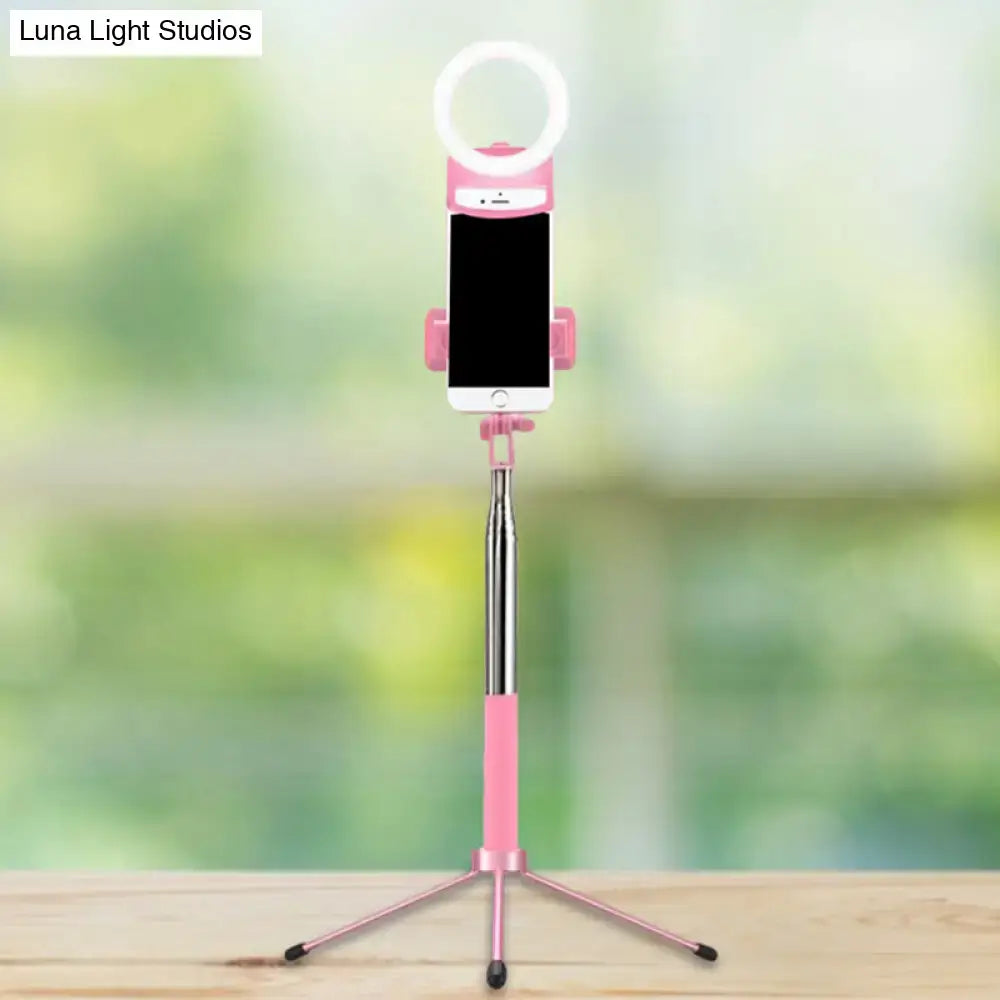 Contemporary pink phone holder with led ring light inch fixture featuring telescoping silver pole and tripod base for bedroom use