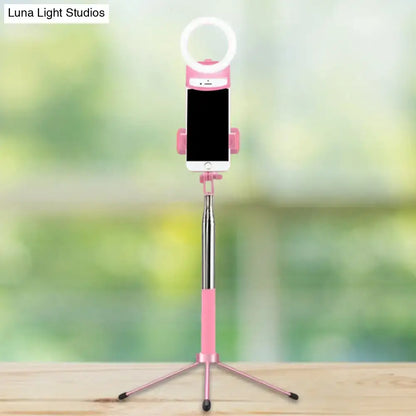 Contemporary pink phone holder with led ring light inch fixture featuring telescoping silver pole and tripod base for bedroom use