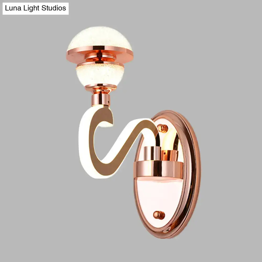 Contemporary rose gold metal urn wall lamp with curved glowing white arm and frosted glass globe for bedroom lighting