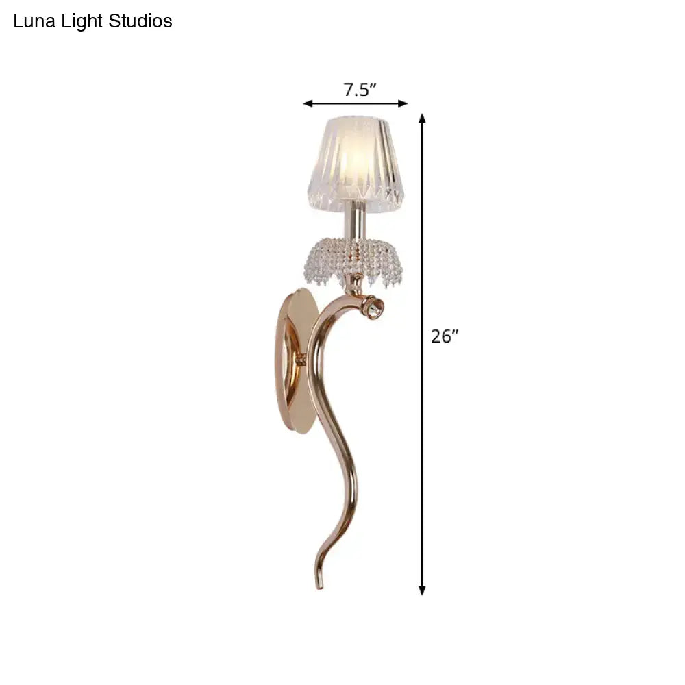 Contemporary rose gold bedroom wall light with gold-toned curved sconce and clear ribbed glass crystal accents