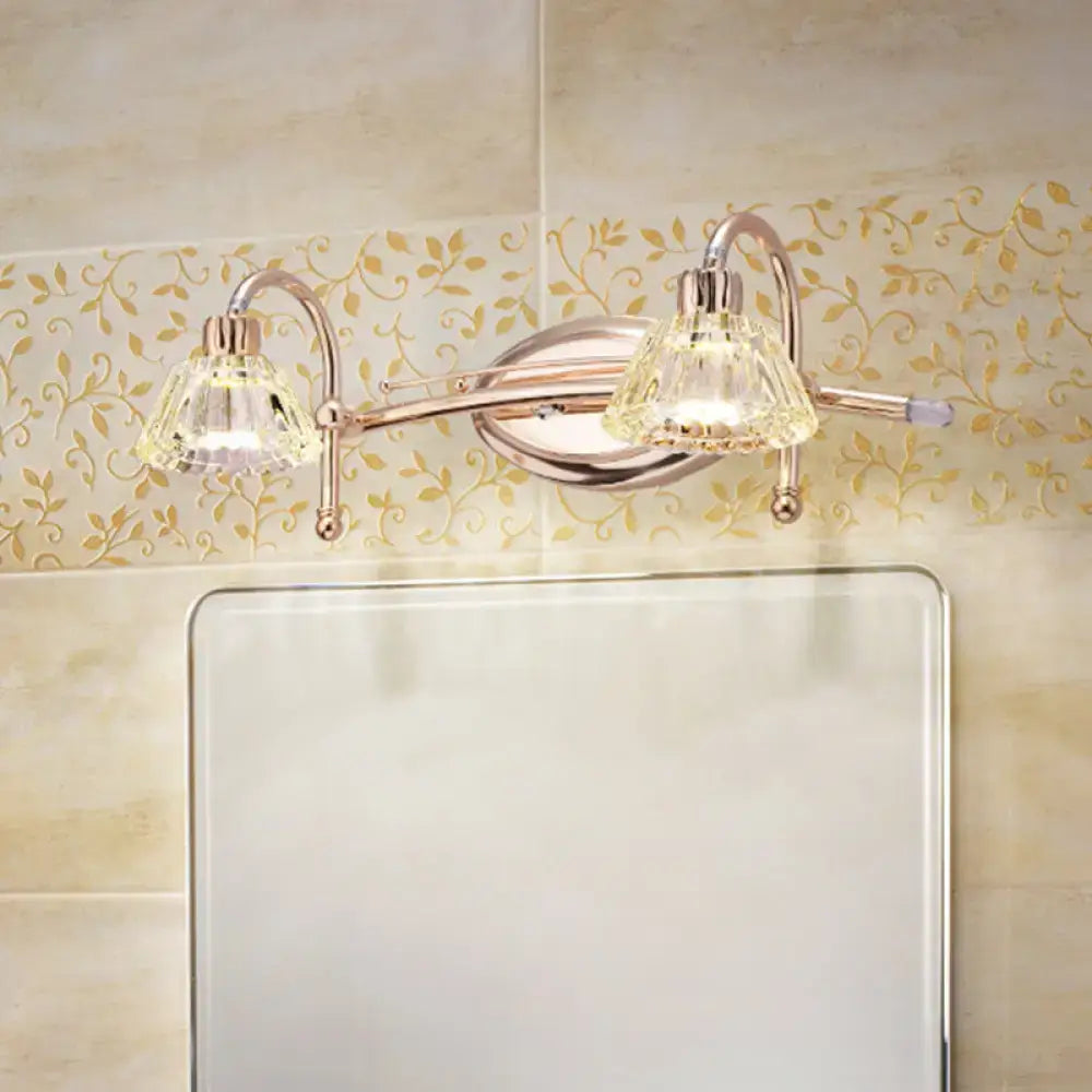 Contemporary rose gold wall vanity light with polished chrome arms and truncated cone crystal shades for bathroom use