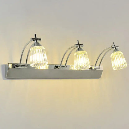 Contemporary silver wall light with three chrome curved arms and faceted crystal shades for vanity light warm white use
