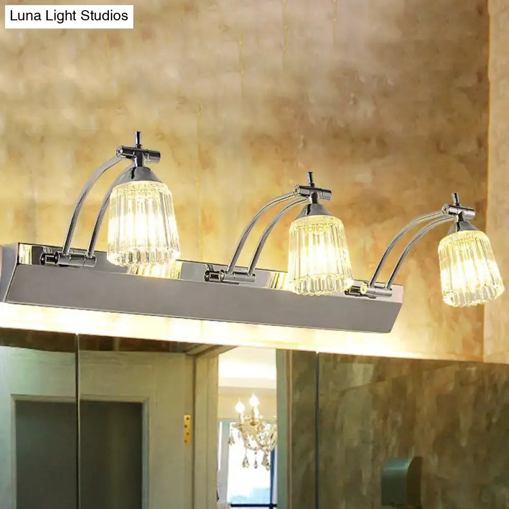 Contemporary silver 3 head crystal vanity light with chrome finish and clear glass shades emitting warm white wall light illumination