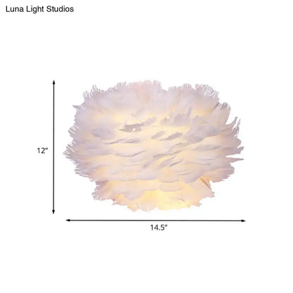 Contemporary white feather wall lamp with a soft, fluffy texture and warm glow for bedroom sconce lighting