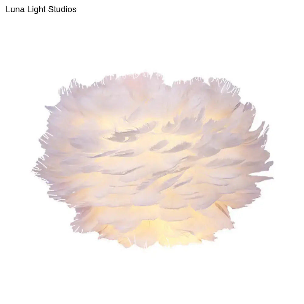 Contemporary white feather wall lamp with a soft fluffy design and warm glow ideal for bedroom sconce lighting