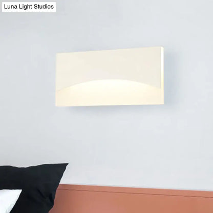 Contemporary cream-colored rectangular wall sconce with smooth glossy finish and warm color temperature for bedrooms