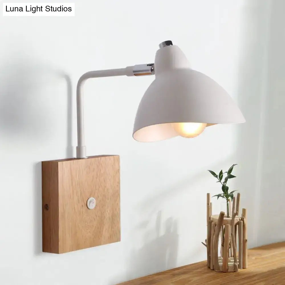 Contemporary white metal wall mounted lamp with wooden base and adjustable arm featuring exposed bulb for bedroom light