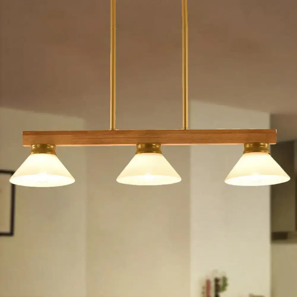 Contemporary wood linear island ceiling light featuring warm tones, frosted glass shades, and gold black brass accents