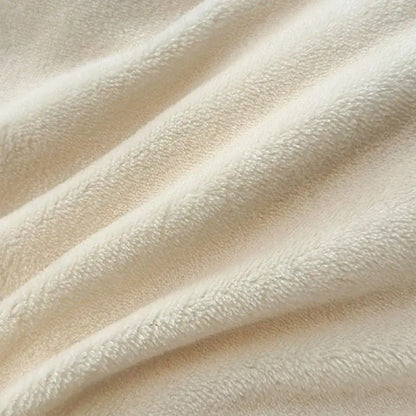 Cream-colored plush fleece blanket with soft textured surface as part of decorbites coral color blocked velvet duvet cover set