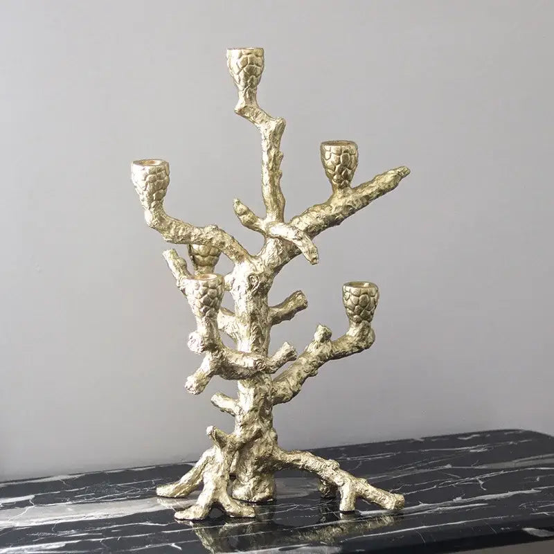 A metallic gold candlestick holder with a textured branch-like design featuring five holders decorbites golden bough