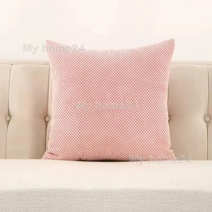 A soft pink corduroy corn kernel throw pillow with woven knit texture on beige tufted sofa for decorbites corduroy corn decor