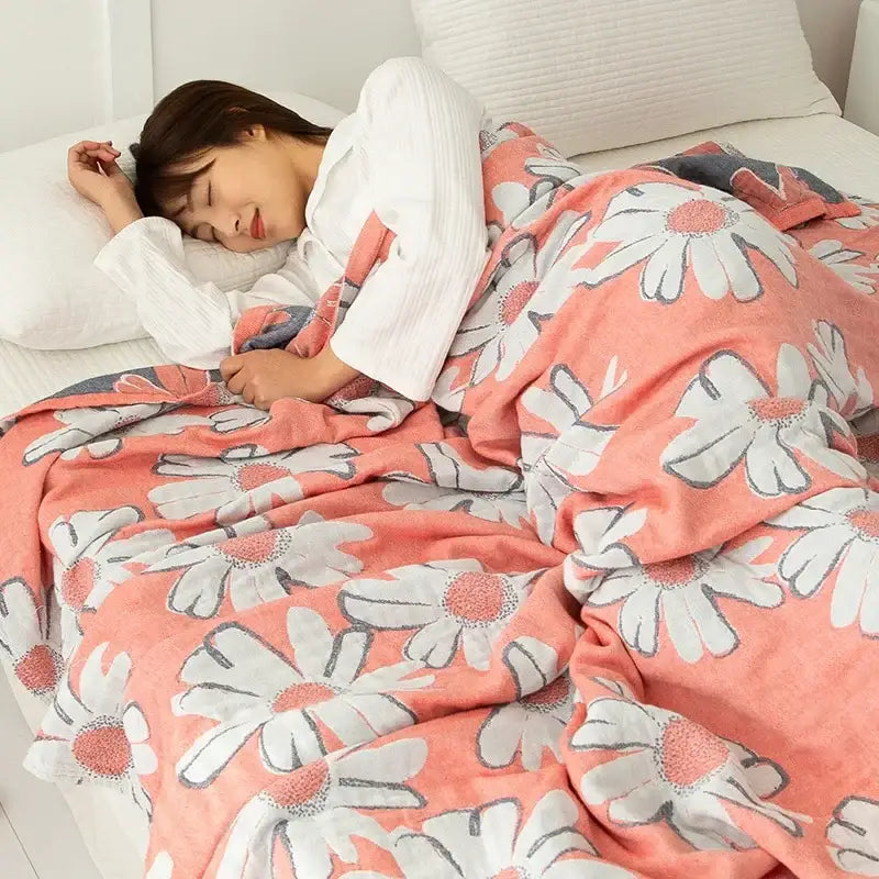 Coralb-colored cotton gauze boho throw with white daisies and gray outlines in soft plush material for bedroom decor