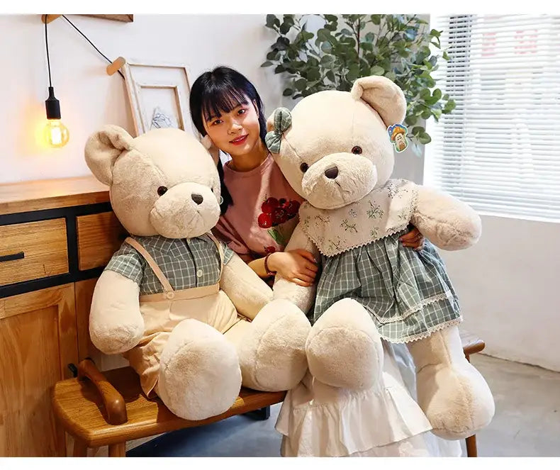 Cream-colored plush toys of a couple bear dressed in green and white plaid outfits with lace aprons for christmas gift