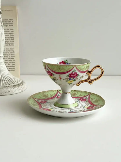 A court style floral porcelain cup set with gold handle featuring pink green and red floral decor for dining room use