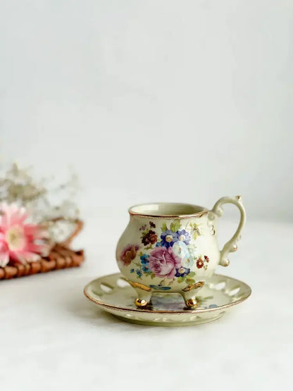 A delicate cream porcelain cup set with intricate floral patterns and gold handle from decorbites court style dining room