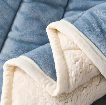 Cozy coral fleece blue and white quilted blanket with soft blue and cream plush exterior and cozy sherpa lining