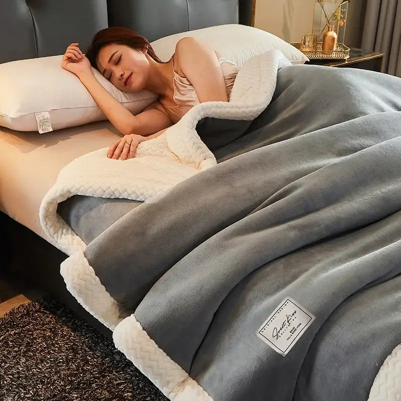A cozy gray and cream two-sided fleece blanket with plush texture and quilted border perfect as a winter fleece blanket