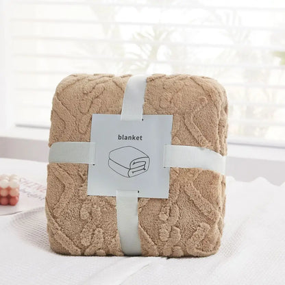 A plush beige fleece cozy jacquard plush blanket with raised floral pattern wrapped in white ribbon for living room decor