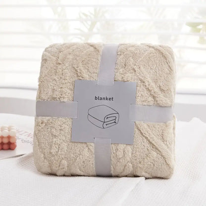 A cream-colored plush blanket with a soft textured surface wrapped in gray ribbon from decorbites cozy jacquard