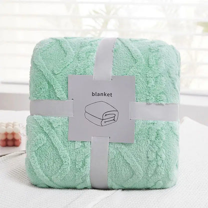 A soft mint green plush blanket with textured looped surface tied with white ribbon for cozy jacquard plush decorbites