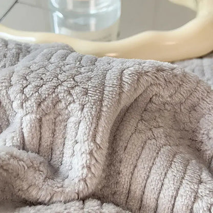 A soft light gray plush blanket with a textured ribbed knit pattern from decorbites cozy striped knitted velvet collection