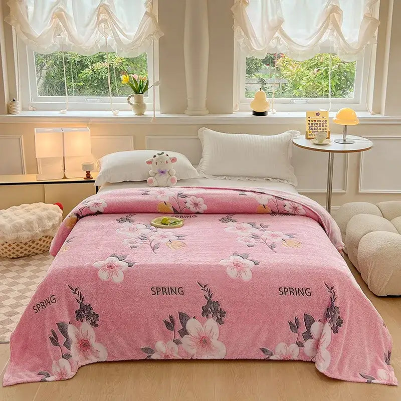 Cozy white fleece blanket with colorful flower patterns and pink floral-patterned spring text, soft plush texture