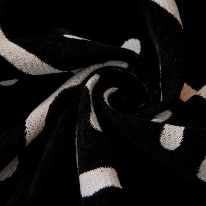 Cream and black cat print chenille sofa cover with black and white striped knit fabric and soft textured weave