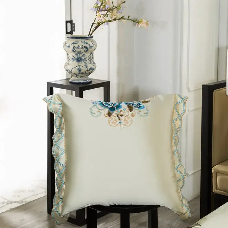 Cream-colored satin pillow with blue and gold embroidery and light blue ruffled edges from 200s embroidery egyptian cotton bedding set