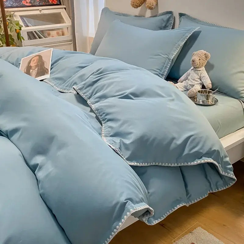 Light blue quilted bedding set with white zigzag stitching along cozy shell edges by decorbites cozy shell